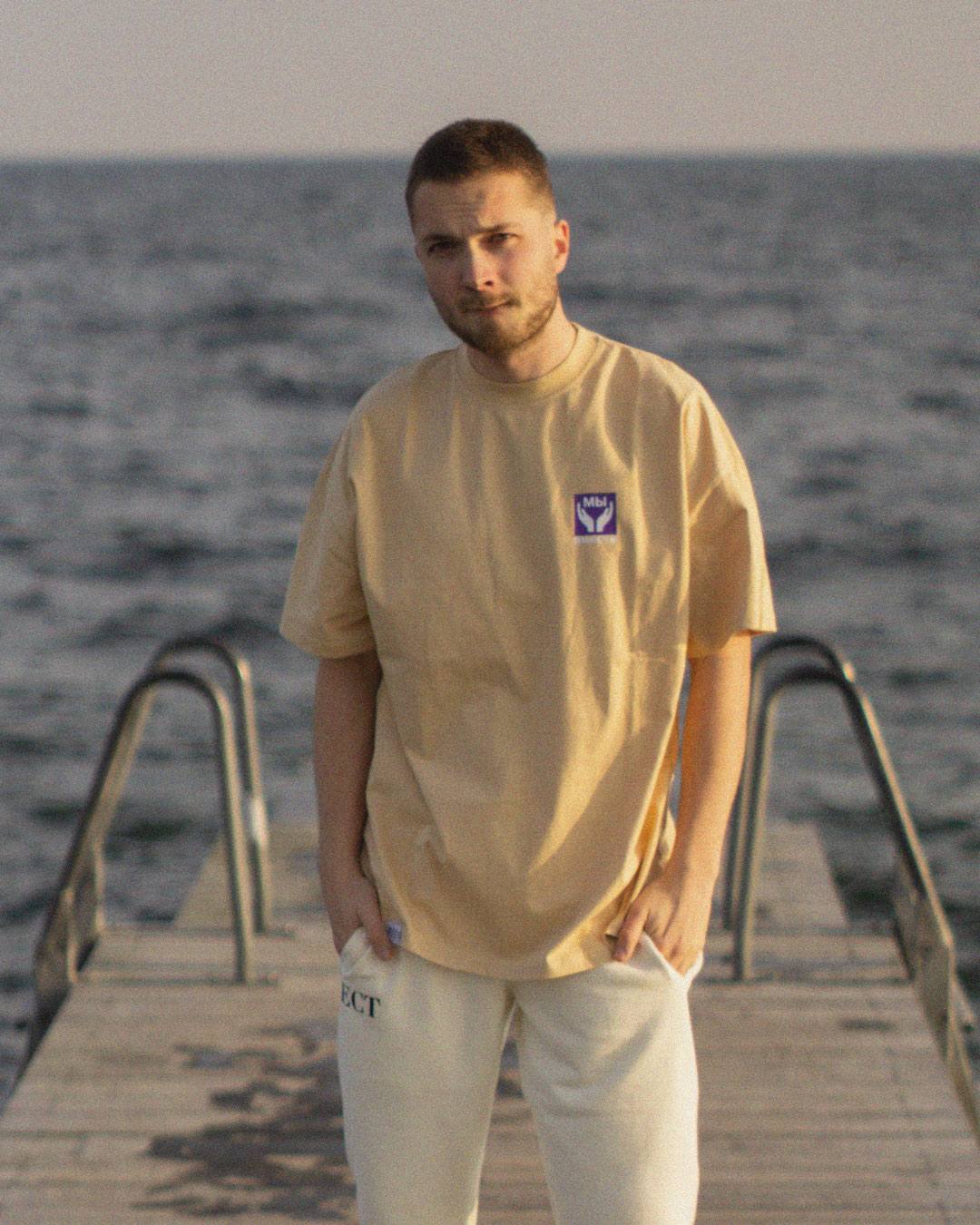 Male Model with BECT We Are Together Tee at Amager beach in Copenhagen, Denkmark, with the ocean in the background